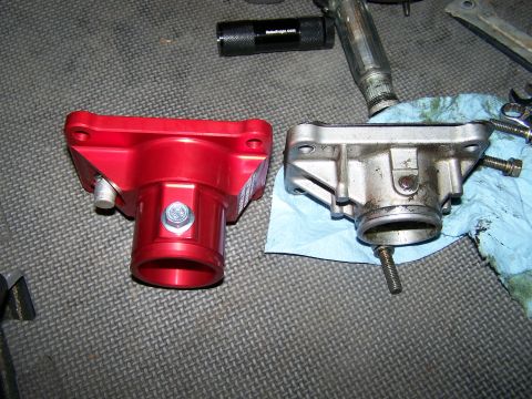 1988 Suzuki Samurai - Two automotive parts, one red and one silver, are laid out on a workbench next to tools.