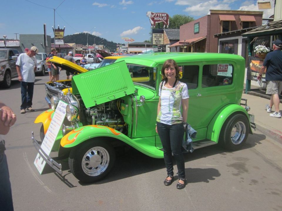 Green 1930s sedan with flames, hood open, showing engine