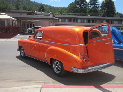 1991 Ford LTD Crown Victoria - An orange panel van is parked outside a motel with its rear doors open.