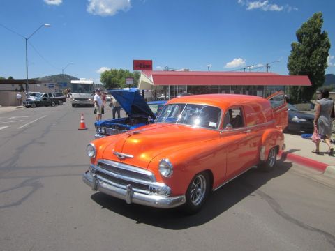 1991 Ford LTD Crown Victoria - A vintage orange panel van is parked at an outdoor car show with a diner in the background.