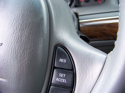 1999 Mercury Grand Marquis - Interior view of a steering wheel showing wear and tear, with cruise control buttons visible.