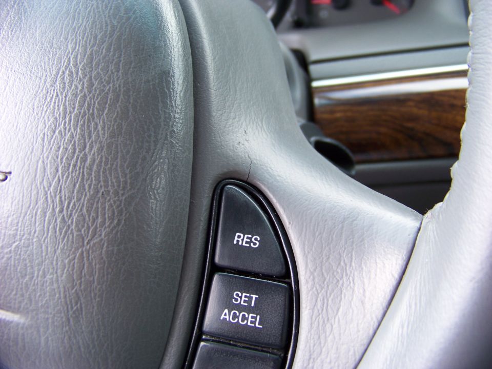 Close-up of a cracked steering wheel with cruise control buttons labeled RES and SET ACCEL
