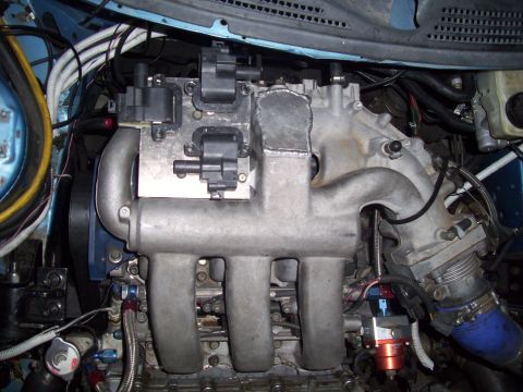 1995 Ford Probe - Close-up view of a vehicle's engine components, including the intake manifold and ignition coils.