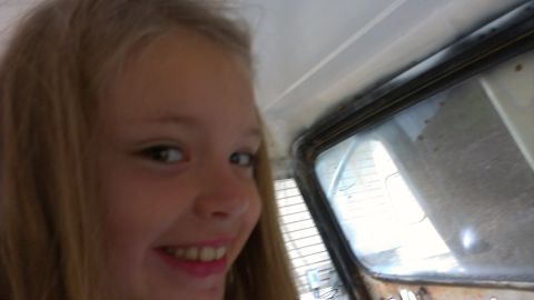 1978 Ford Bronco - A young girl smiles for the camera from inside a vehicle.