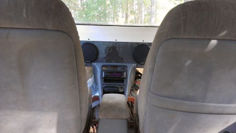 1978 Ford Bronco - Interior view of a vehicle showing the front seats, center console, and dashboard speakers.