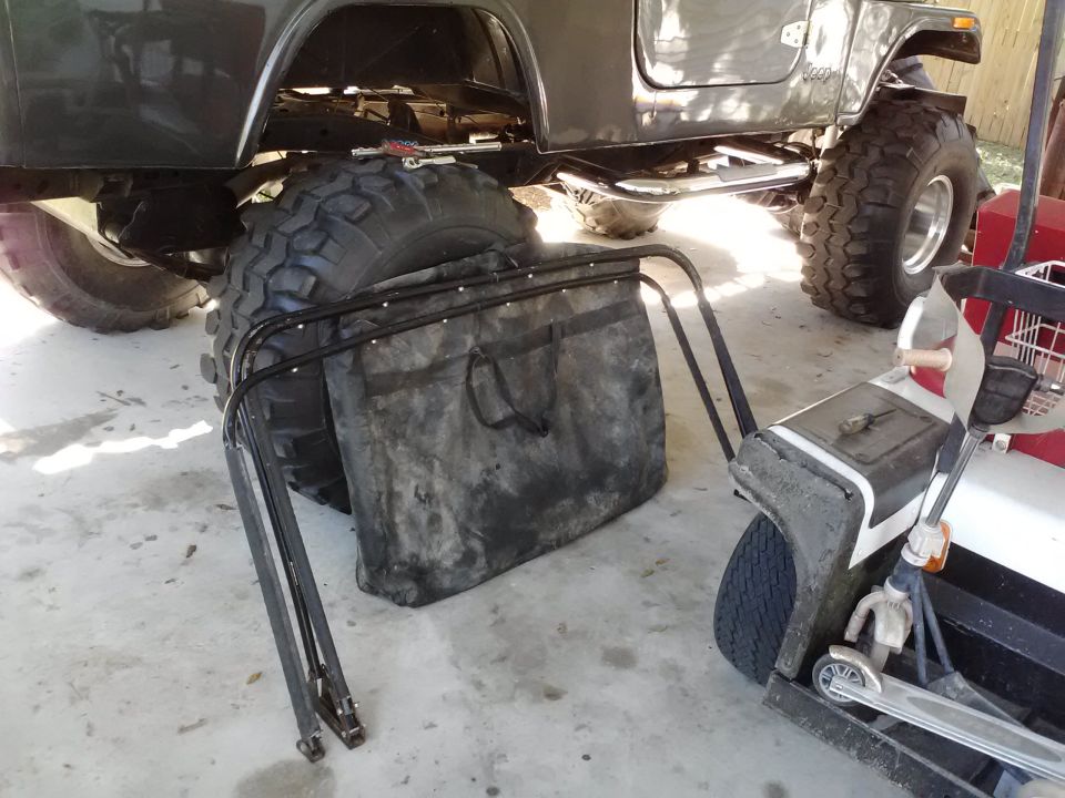 Gray SUV side view with large tires, lawn bag, and golf cart