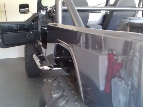 1978 Ford Bronco - Interior view of a dark SUV, showing the roll cage and an open driver's side door.