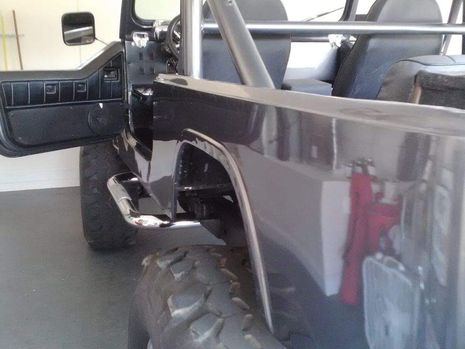 Dark SUV interior with roll cage and open door