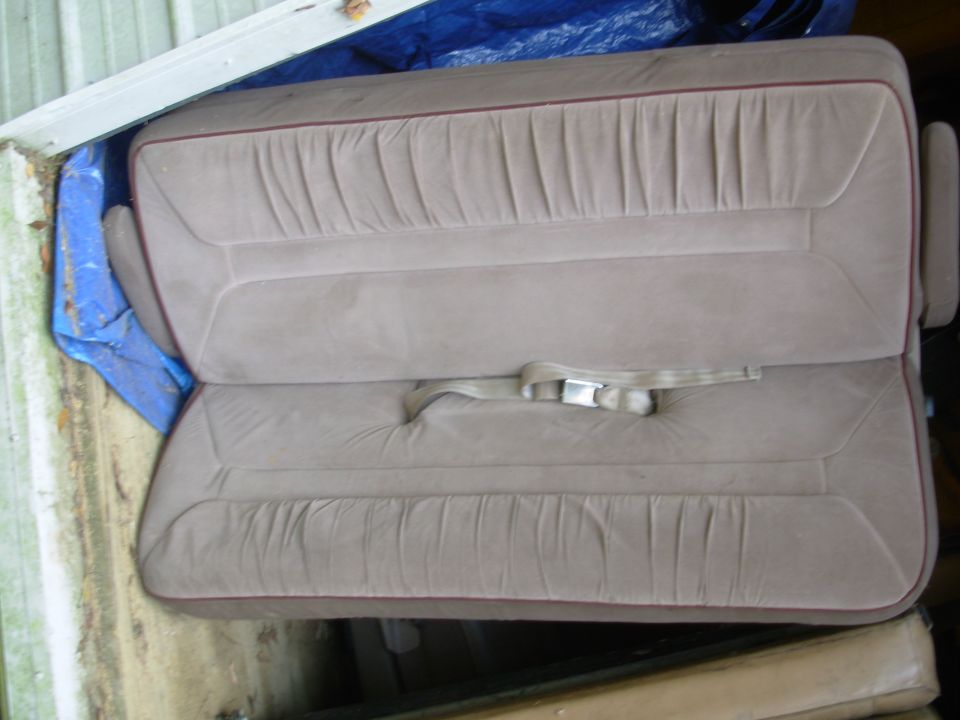 Convertible Bench/Bed from '96E150
140lbs as-is
laid flat: 56"Wx70"L (60"W w/armrests)
min. height w/o floor brackets: 10"

It does NOT normally fold forward or collapse for storage.  But if unbolted from the floor brackets, it would probably compact to about 60Lx26Dx18H.  I haven't disassembled it to find out.