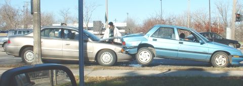 1986 Ford Bronco - A collision occurred between a gold sedan and a light blue sedan on a street.
