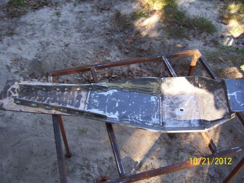 1990 Ford Bronco - A metal frame section, possibly from a vehicle, is being worked on outdoors.