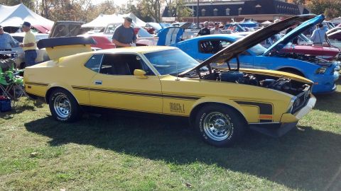 2007 Ford Mustang - A yellow 1971 Ford Mustang Mach 1 is displayed at an outdoor car show with its hood open.