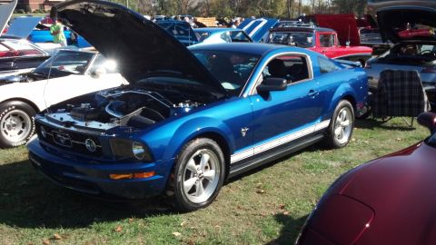 2007 Ford Mustang - A blue Ford Mustang is displayed with its hood up at an outdoor car event, surrounded by other vehicles.