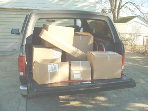 1986 Ford Bronco - Cardboard boxes are loaded into the back of a Ford Bronco.