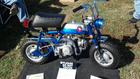 2007 Ford Mustang - A blue and silver Honda Z50 minibike is displayed on a black mat with a "Please Do Not Touch" sign in front of it.