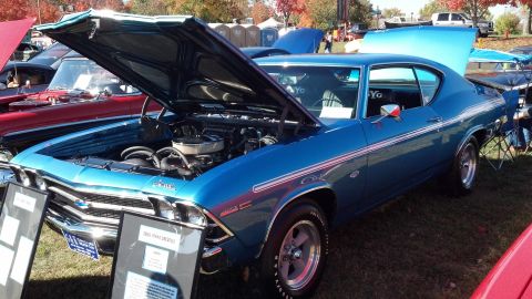 2007 Ford Mustang - A blue 1969 Chevrolet Chevelle SS is displayed with its hood open at an outdoor car show.
