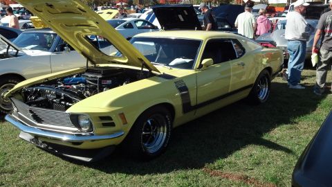 2007 Ford Mustang - Yellow 1970 Ford Mustang Boss 302 displayed at an outdoor car show with its hood open.