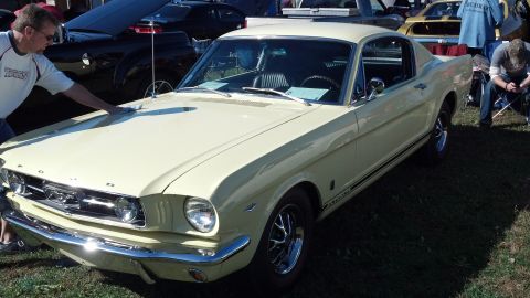 2007 Ford Mustang - Pale yellow 1965 Ford Mustang coupe at a car show, with other vehicles in the background.
