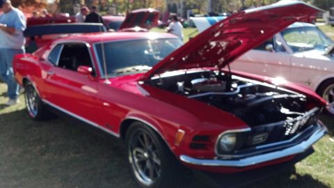 2007 Ford Mustang - A red 1970 Ford Mustang is displayed with its hood open at an outdoor car show.