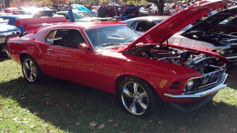 2007 Ford Mustang - A red 1970s Ford Mustang coupe is displayed with its hood open at an outdoor car show.