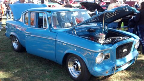 2007 Ford Mustang - A blue Studebaker Lark SS is displayed with its hood open at an outdoor event.