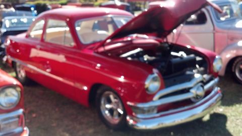 2007 Ford Mustang - A red classic coupe is displayed with its hood open, parked next to another vehicle.