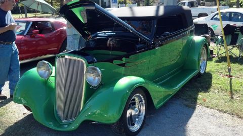 2007 Ford Mustang - A custom green hot rod with its hood up is displayed at an outdoor event, with another car visible in the background.