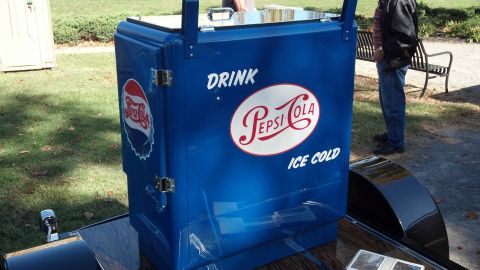 2007 Ford Mustang - A vintage Pepsi-Cola ice chest sits outdoors on a trailer, with a person standing nearby.