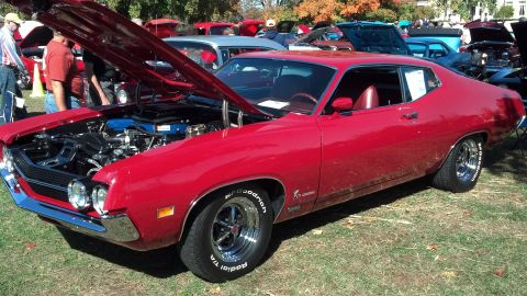 2007 Ford Mustang - A red 1970 Ford Torino coupe is displayed with its hood open at an outdoor car show.