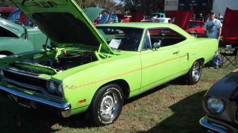 2007 Ford Mustang - A bright green 1970 Plymouth Road Runner is displayed with its hood up at a car show.