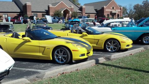 2007 Ford Mustang - Yellow Corvettes are displayed at a car show event with multiple vehicles present.
