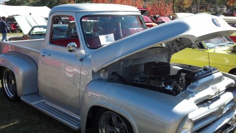 2007 Ford Mustang - A classic silver pickup truck is displayed with its hood open, revealing the engine.