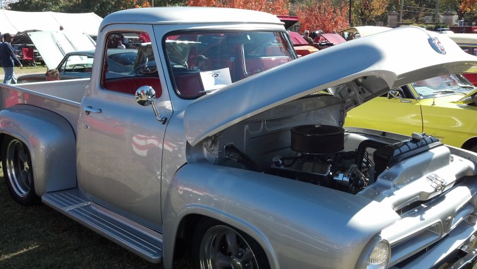 Silver pickup truck with hood open, red interior, and chrome accents