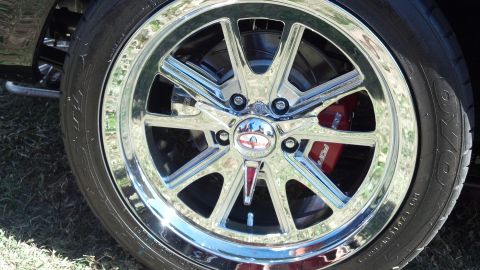 2007 Ford Mustang - Close-up of a shiny chrome wheel and a red brake caliper with visible text.