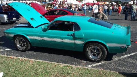2007 Ford Mustang - A teal 1970 Ford Mustang is parked with its hood open at an outdoor event.