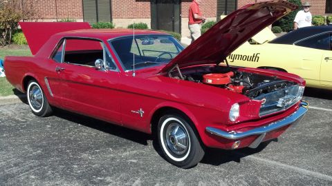 2007 Ford Mustang - A red classic coupe is parked with its hood open, next to a yellow car.