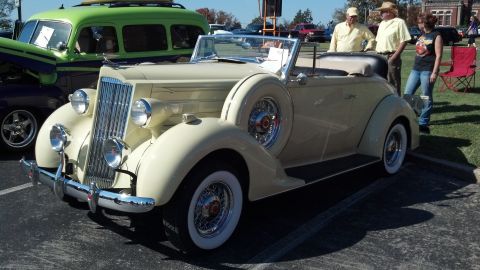 2007 Ford Mustang - A vintage cream-colored convertible is displayed at an outdoor event.