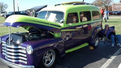 2007 Ford Mustang - A customized panel van, painted purple and lime green, is displayed with its hood open. A Woody doll sits in the driver's seat.