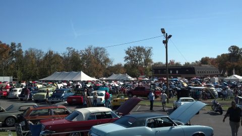 2007 Ford Mustang - A sunny day at a car show with numerous vehicles on display and attendees mingling.