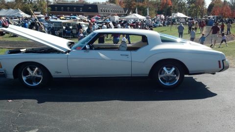 2007 Ford Mustang - A white coupe with its hood open is parked at an outdoor event with other vehicles and tents in the background.