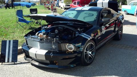 2007 Ford Mustang - A black Ford Mustang with racing stripes is displayed with its hood open, revealing the engine bay.
