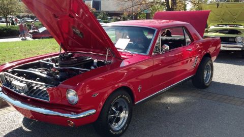 2007 Ford Mustang - A red 1965 Ford Mustang coupe is displayed with its hood open, parked next to another vehicle.