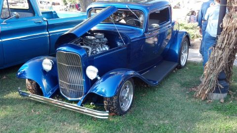 2007 Ford Mustang - A classic blue hot rod coupe with its hood open, parked next to a blue truck.
