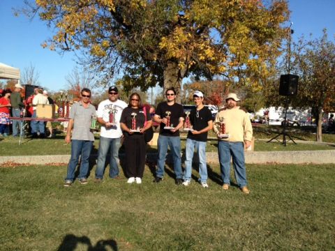 2007 Ford Mustang - A group of individuals pose for a photo, each holding a trophy, under a tree with autumn foliage.