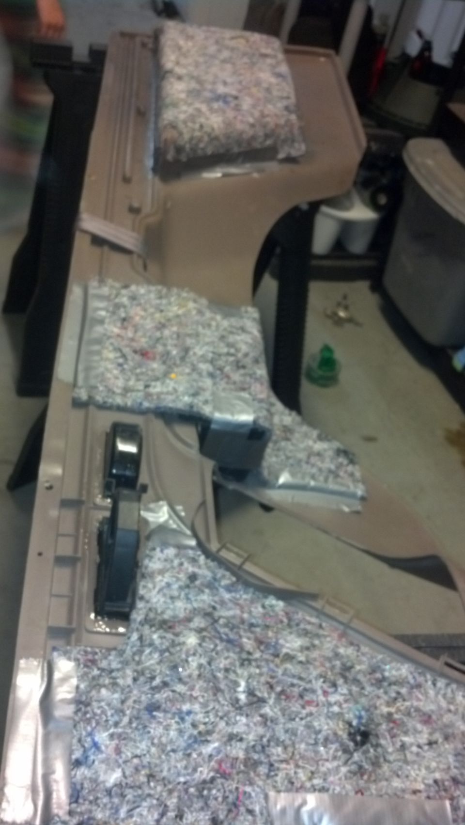 Tan car interior door panel with insulation material and black plastic components. Watermark "SUPERMOTORS.NET" visible