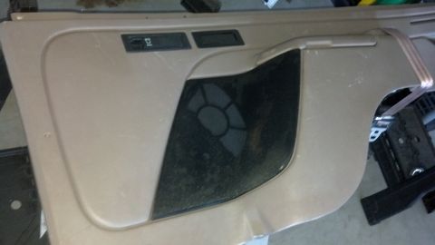 1995 Ford Bronco - A close-up view of a vehicle's interior door panel, showing the speaker grille and control buttons.