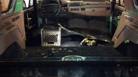 1995 Ford Bronco - The interior of a 1995 Ford Bronco shows signs of disassembly, with the dashboard and door panels removed.
