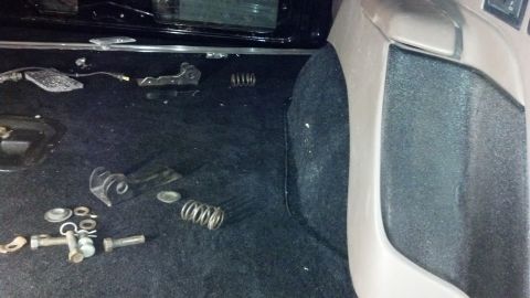 1995 Ford Bronco - Disassembled parts and springs are visible on the carpeted floor of a vehicle's interior.