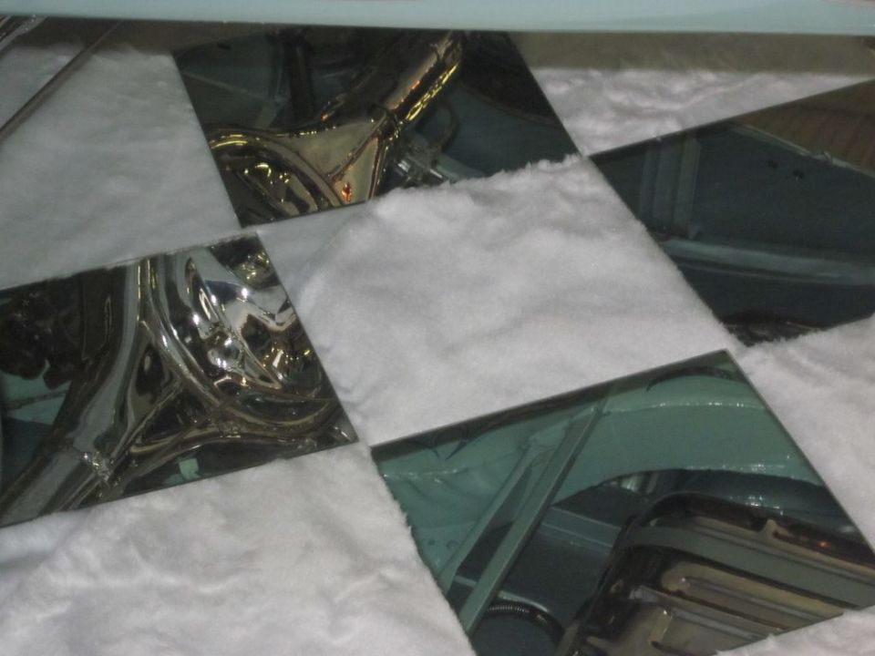Car interior with reflective chrome trim and white padding, viewed from above