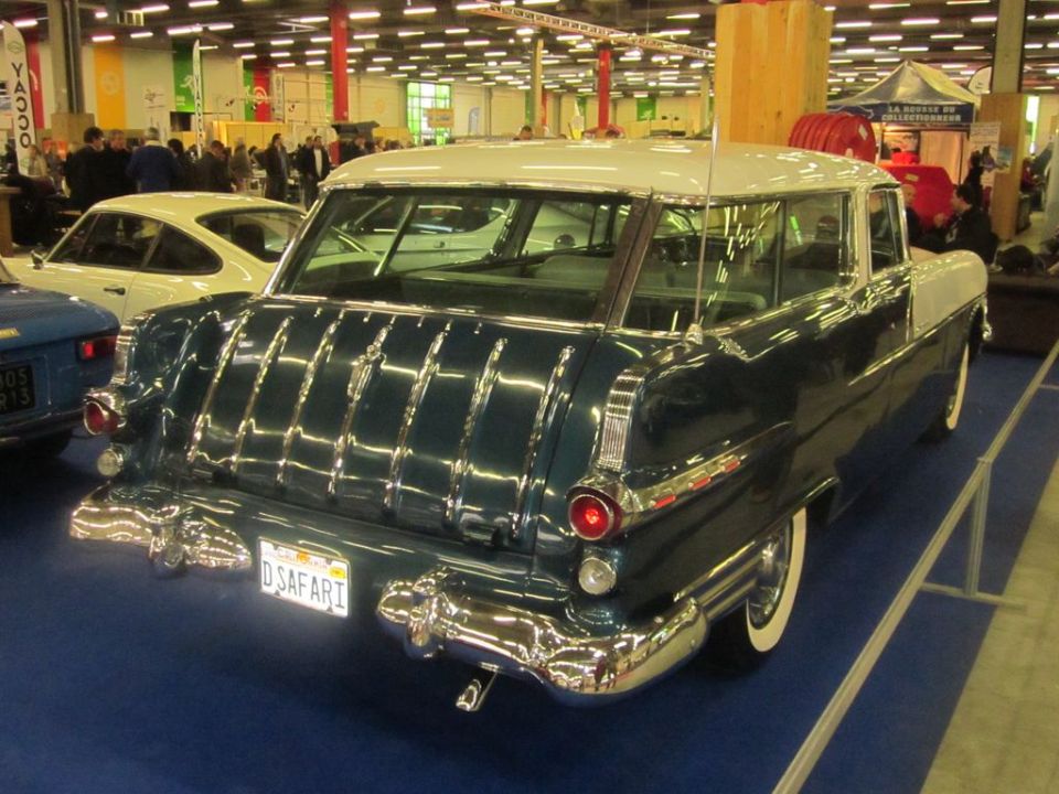 Rear view of a 1955 station wagon with a chrome tailgate and white roof